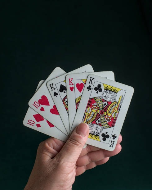 Live baccarat dealer at gaming table dealing cards to multiple camera angles